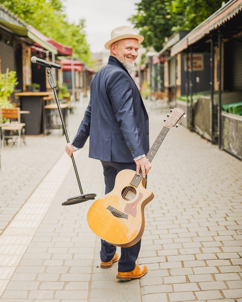 DJ Markus mit Gitarre und Mikrofonständer "auf dem Weg zu Ihnen"